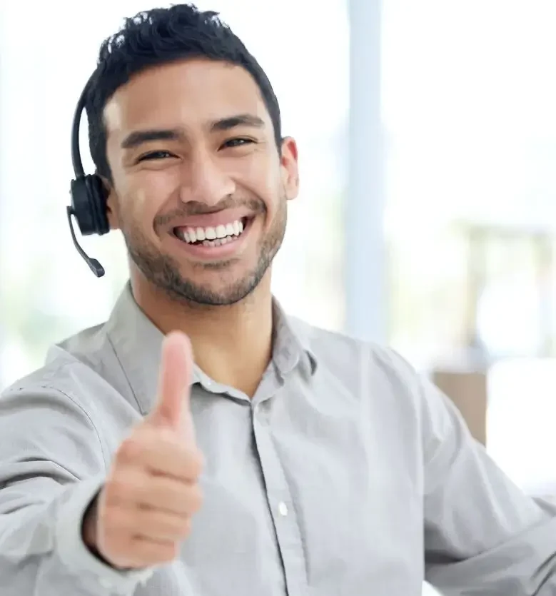 An RV customer support representative wearing a headset gives a thumbs-up.