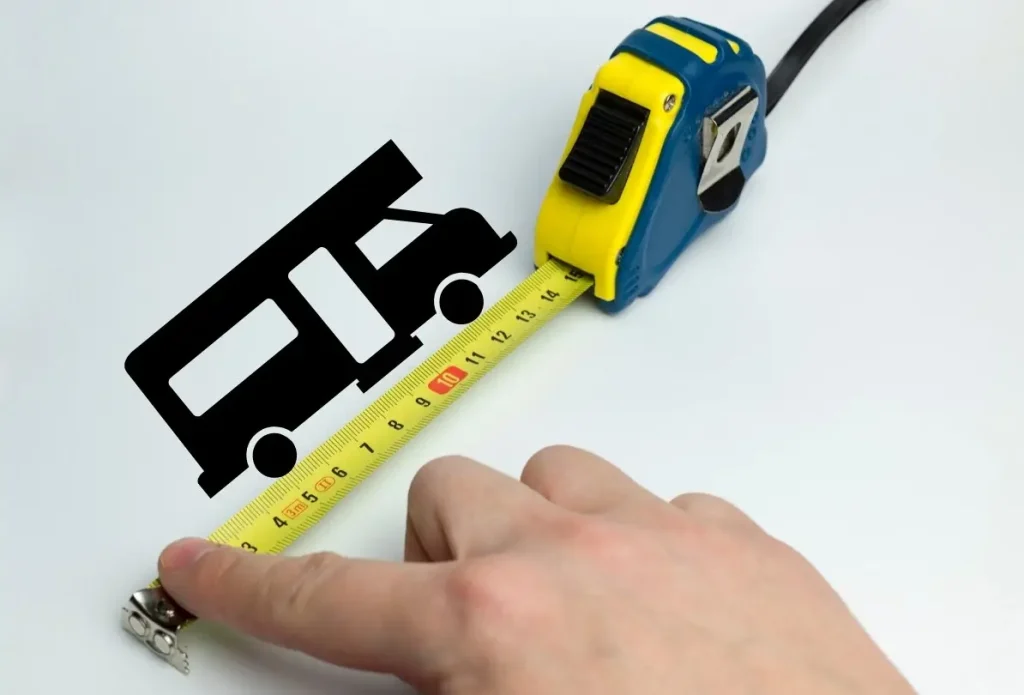 A measuring tape measuirng a stencil of a small Class A RV on a piece of paper.