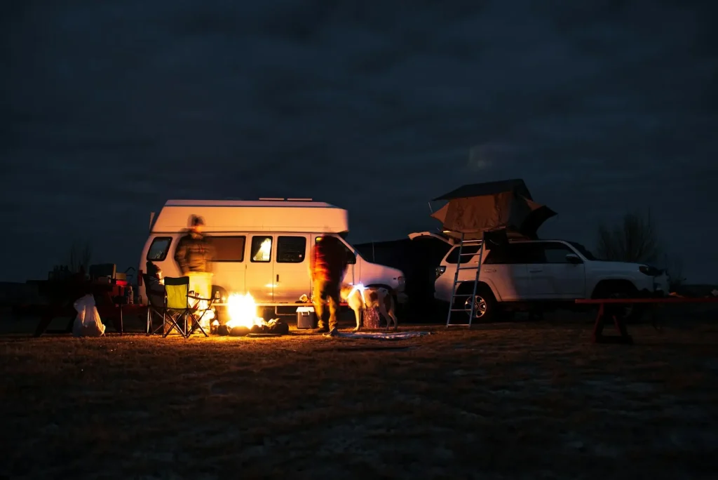 A group of several RV groups dispersed camping in a wilderness area together with a campfire.