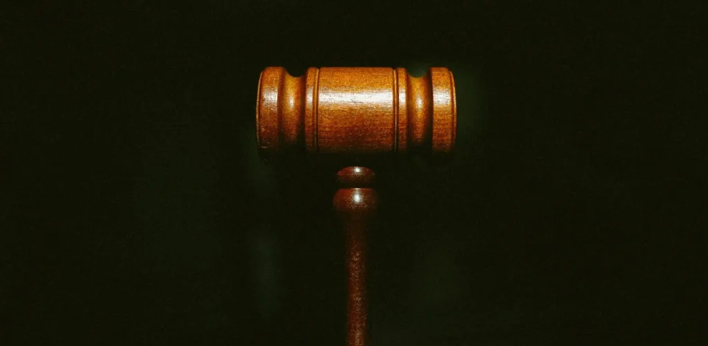 A wooden gavel on a black background representing the complex framework of local reuglations, ordinances, and zoning laws affecting full-time RV living.