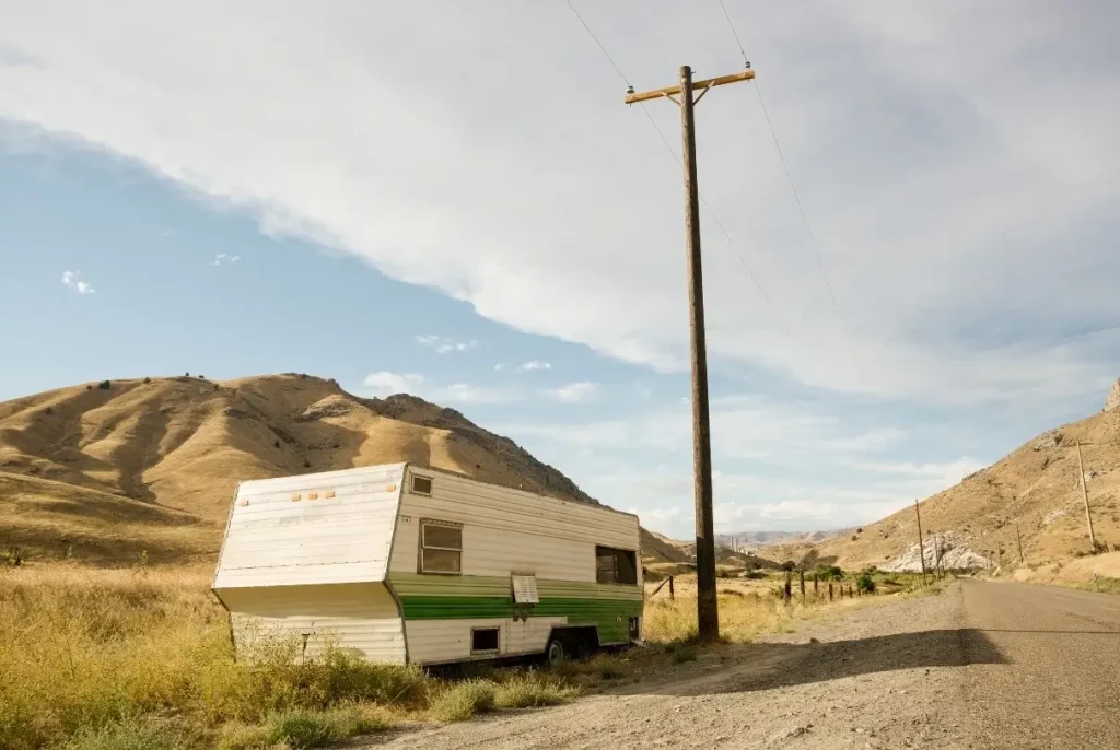 An abandoned trailer RV left on the side of the road in a drier region of eastern Oregon.