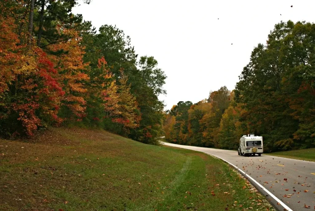 A motorhome driving down a scenic country road in Mississipi en route to a fantastic RV park under $500 a month.