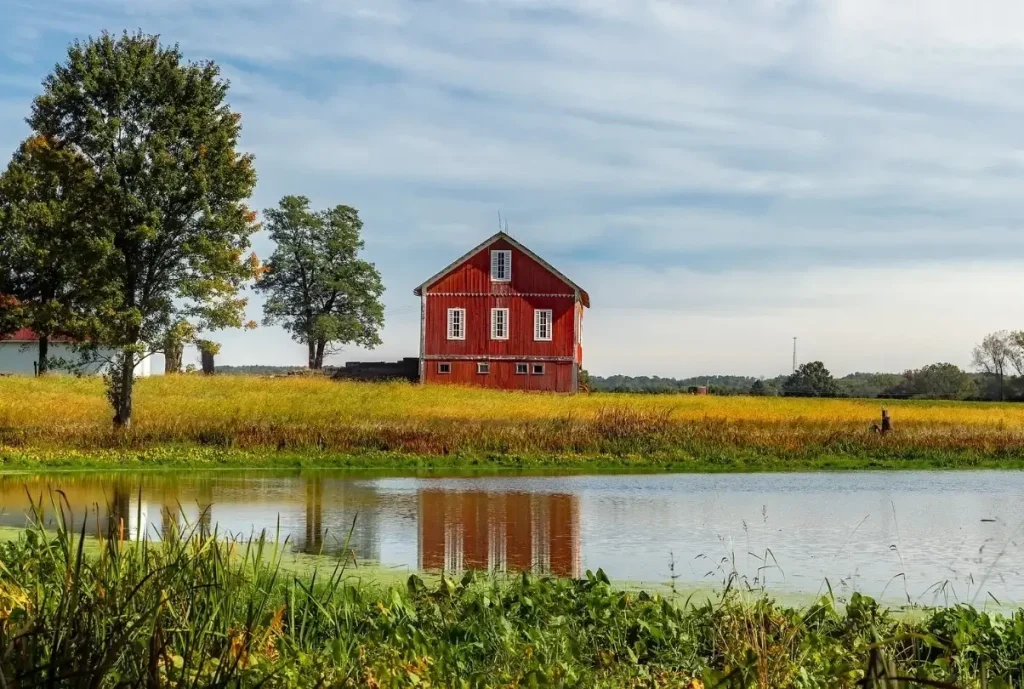 A classic red barn sitting by a lake on a rural farm in Ohio.