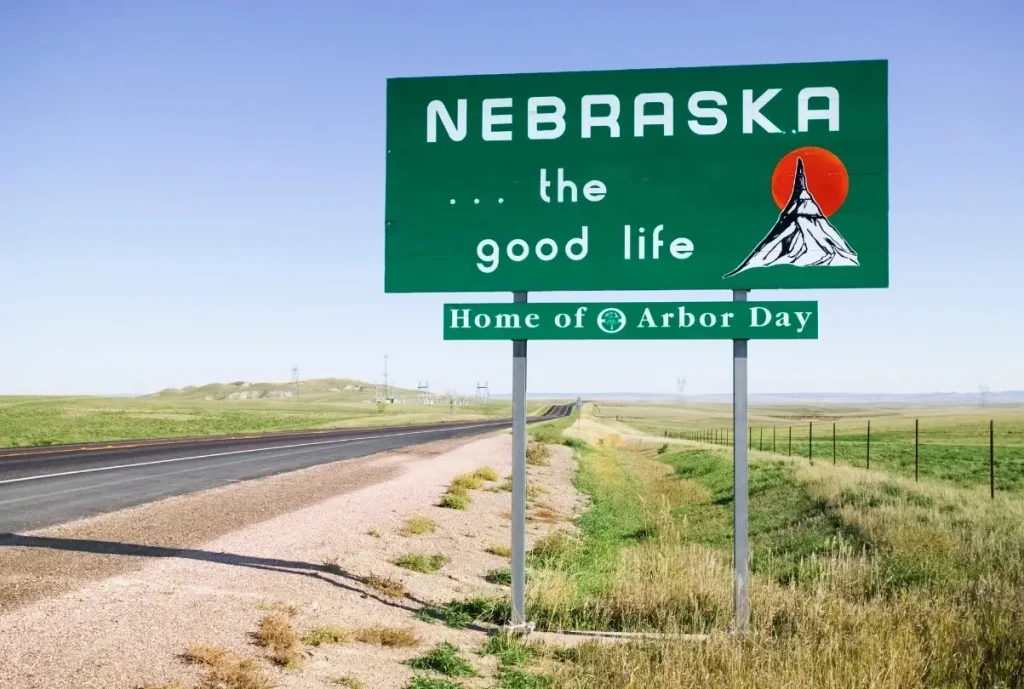 A 'Welcome to Nebraska' sign at the border of the state with the words "Nebraska... the good life." written on it.