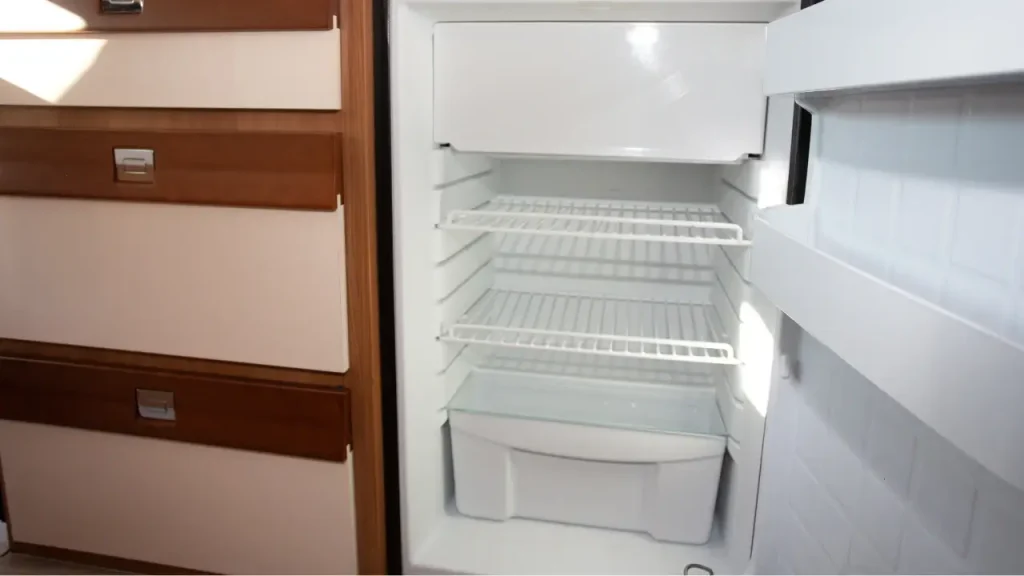 One of the best RV refrigerators installed in a motorhome, open with its door ajar and interior empty.