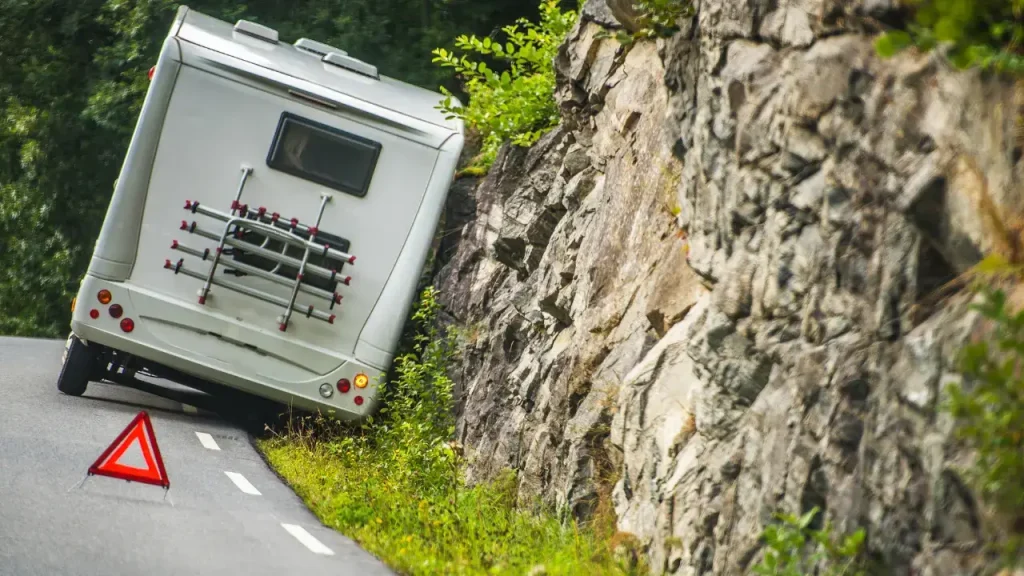 A motorhome stranded on the shoulder of a mountain road, waiting for service technicians courtesy of their registration with one of the best RV roadside assistance plans.