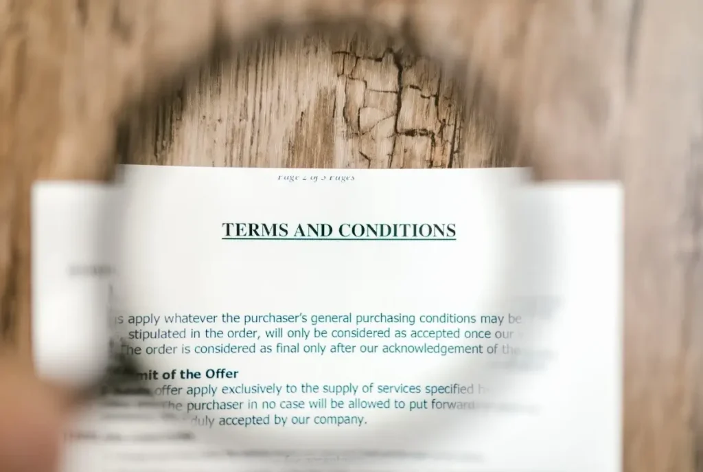 A magnifying glass placed over an RV's extended warranty policy's terms and conditions to read the fine print.