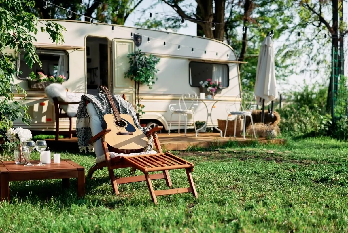 A wonderful semi-permanent caravan setup based in a green forest and decorated with an array of the best RV accessories.