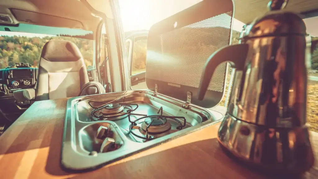 Stunning view of the sunrise over the mountain side, seen from the kitchen of a campervan.