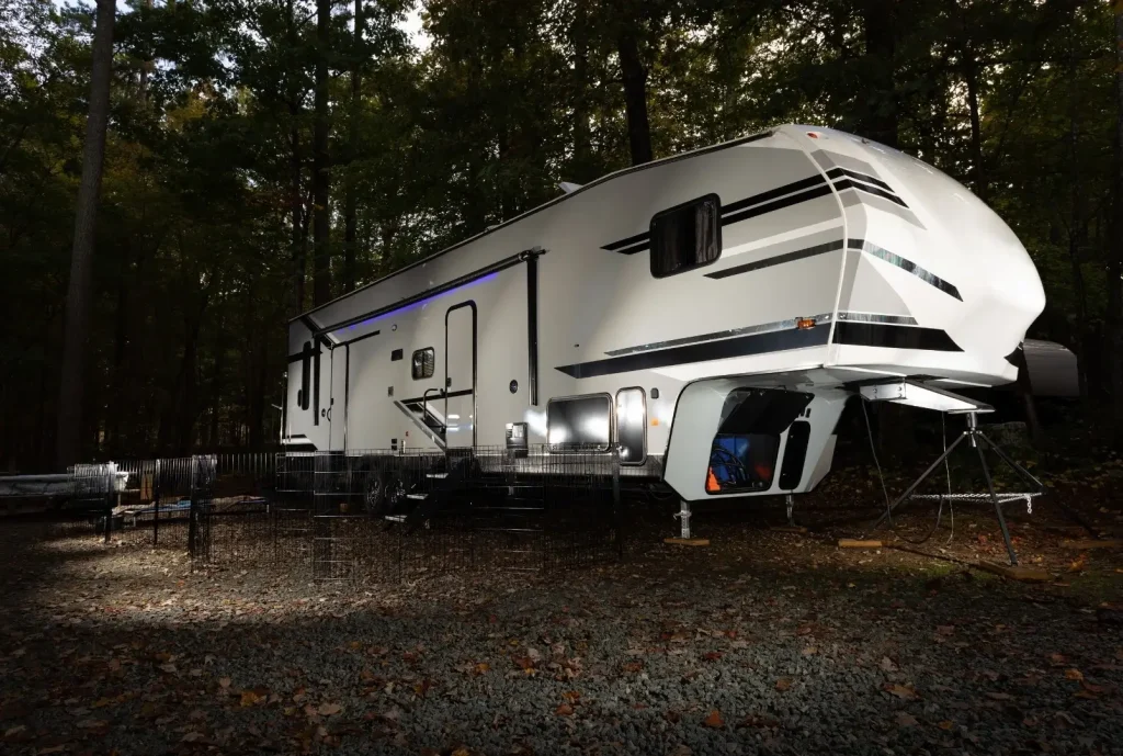 A Keystone fifth wheel is parked at a local RV site, showcasing its innovative soft-glowing neon awning light.