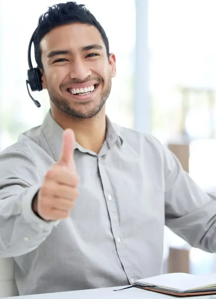 An RV customer support representative wearing a headset gives a thumbs-up.