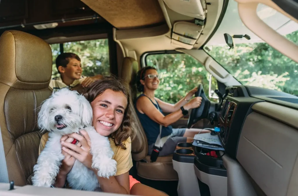 Family in their RV with their dog off on their first camping trip of the spring after completing their dewinterization tasks.