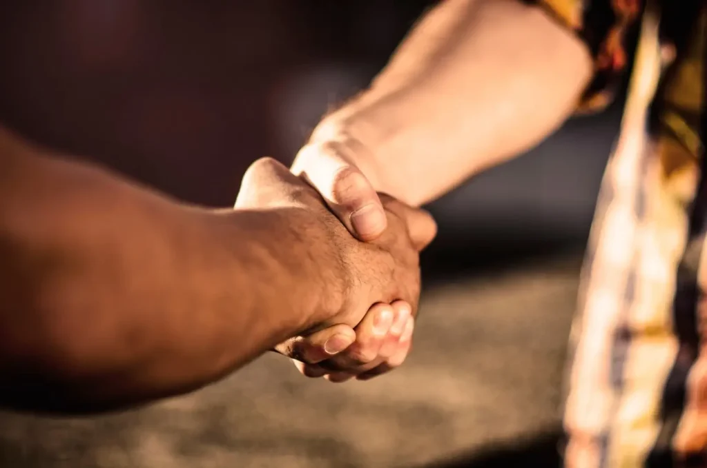 Two gentlemen shake hands after agreeing on a sales price for an RV.